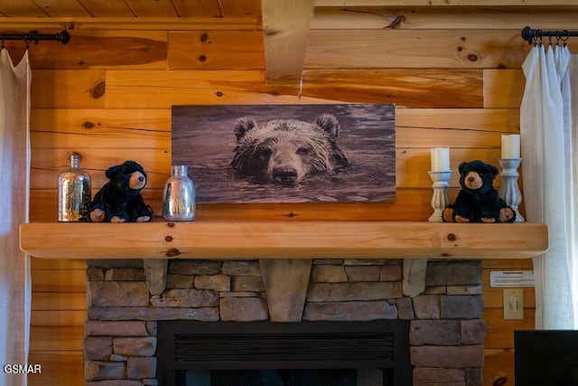 room details with a stone fireplace and wood walls