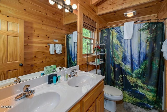 bathroom featuring double vanity, wood walls, toilet, and a sink