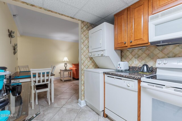 3215 N River Rd Ste 503, Pigeon Forge, TN 37863 - kitchen with a drop ceiling, white appliances, stacked washer and dryer, decorative backsplash, and light tile patterned floors