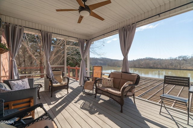 wooden terrace with an outdoor living space, ceiling fan, and a water view