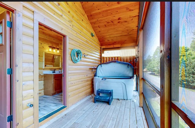 sunroom with a hot tub, wood ceiling, and vaulted ceiling