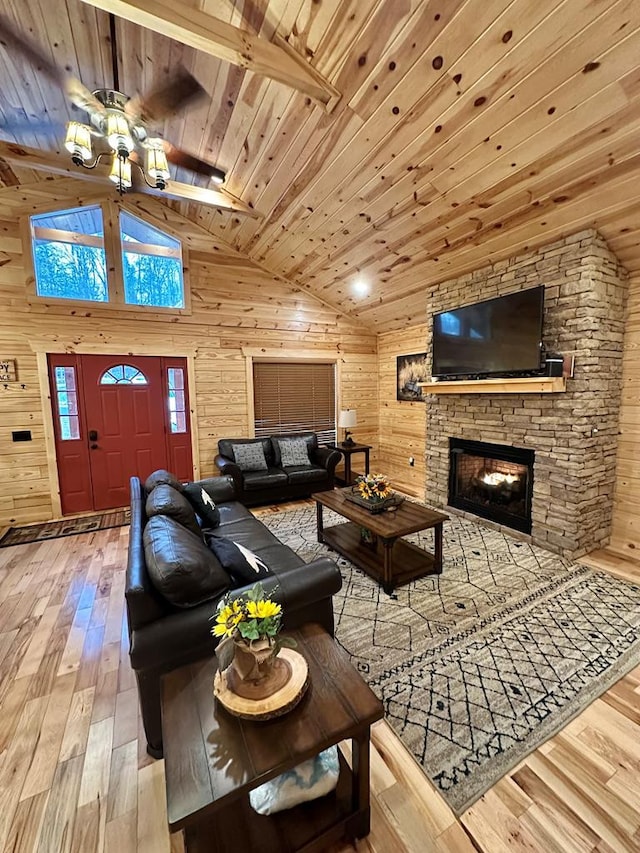 living room with ceiling fan, wood walls, and wood ceiling