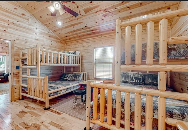 bedroom with hardwood / wood-style floors, wood walls, lofted ceiling, wooden ceiling, and ceiling fan