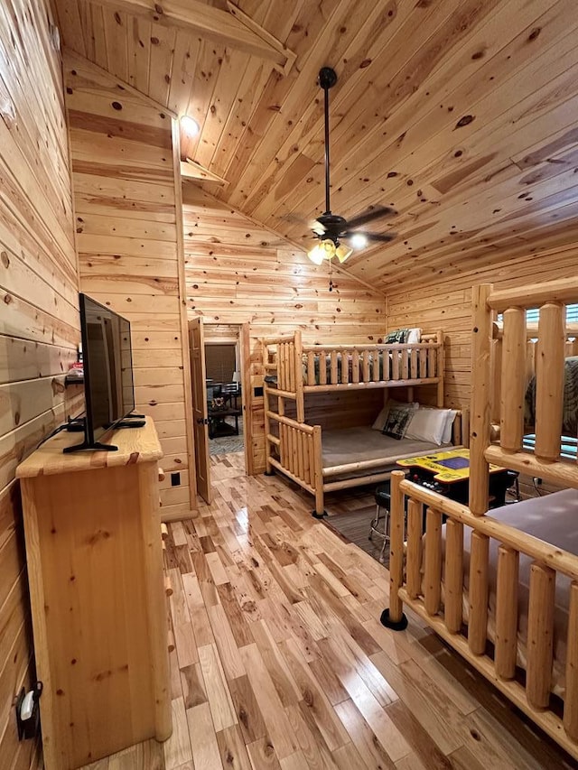 bedroom featuring wood walls, light wood-type flooring, lofted ceiling, and wood ceiling