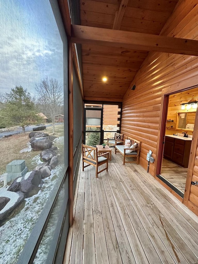 sunroom featuring wooden ceiling, sink, and lofted ceiling with beams