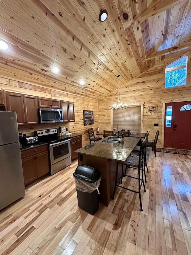 kitchen with a center island, hanging light fixtures, wooden ceiling, stainless steel appliances, and a kitchen bar