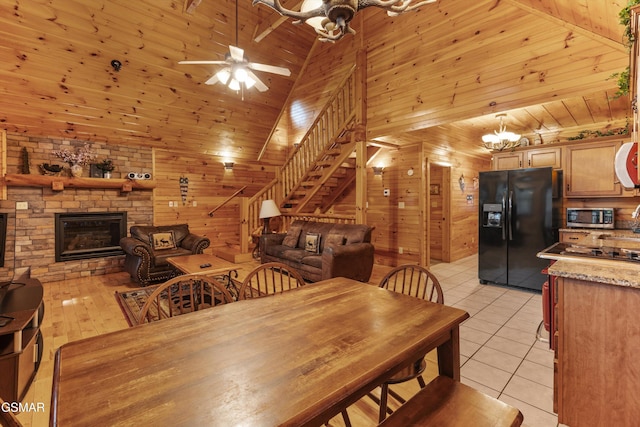 dining space with wood walls, stairs, light tile patterned flooring, and wood ceiling
