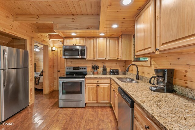 2377 Alpine Village Way, Pigeon Forge, TN 37863 - kitchen featuring appliances with stainless steel finishes, a sink, wood ceiling with exposed beams, light brown cabinetry, and wooden walls