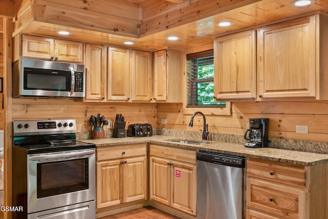 2377 Alpine Village Way, Pigeon Forge, TN 37863 - kitchen with stainless steel appliances, light brown cabinets, a sink, light stone countertops, and wooden walls