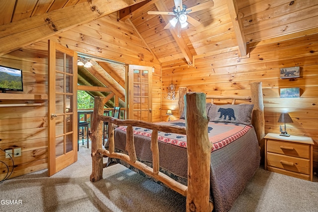 carpeted bedroom with french doors, lofted ceiling with beams, wooden ceiling, and wooden walls