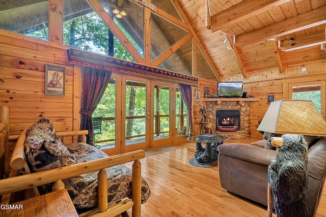 living room featuring hardwood / wood-style floors, wood walls, a fireplace, beam ceiling, and wood ceiling