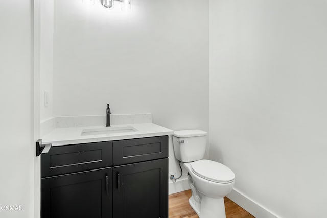 bathroom featuring toilet, vanity, and hardwood / wood-style flooring