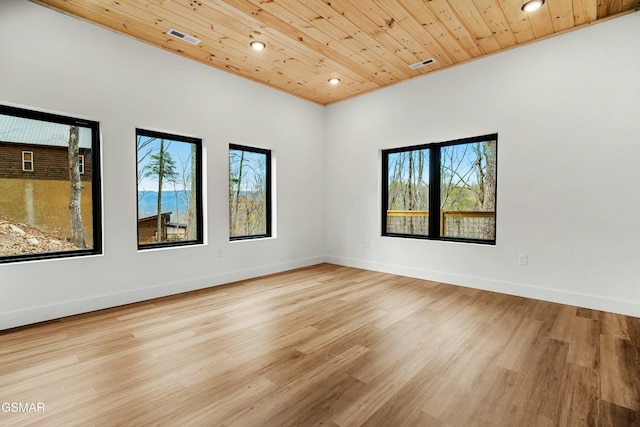 empty room with a wealth of natural light, light hardwood / wood-style floors, and wood ceiling