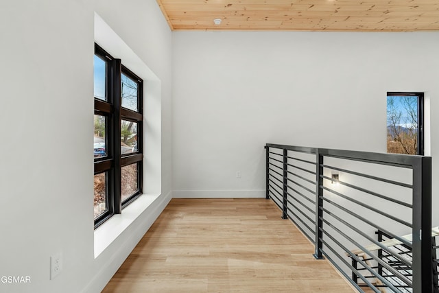 hallway featuring light wood-type flooring and wood ceiling