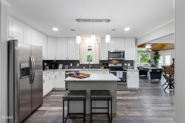 2887 Pine Haven Dr, Sevierville, TN 37862 - kitchen with appliances with stainless steel finishes, a sink, decorative backsplash, white cabinets, and ornamental molding