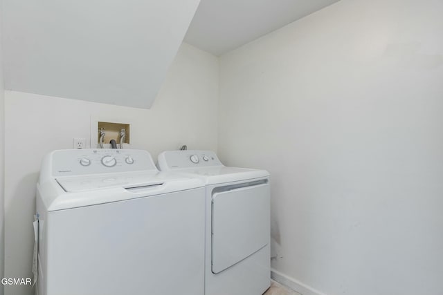 washroom with laundry area, washing machine and dryer, and baseboards