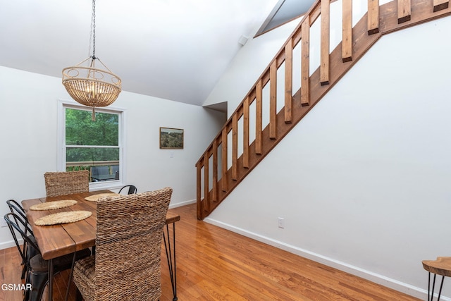 dining area with stairs, light wood-type flooring, baseboards, and an inviting chandelier