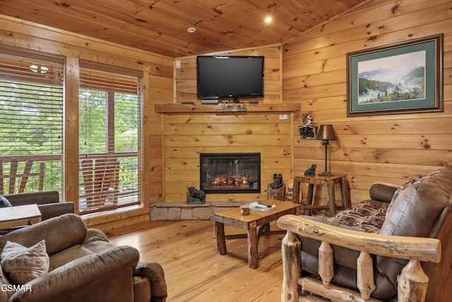 1830 Blue Tick Way, Sevierville, TN 37876 - living room featuring lofted ceiling, wood ceiling, wood walls, wood finished floors, and a glass covered fireplace