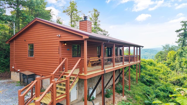 1830 Blue Tick Way, Sevierville, TN 37876 - rear view of house with log veneer siding, a chimney, a deck, and a metal roof