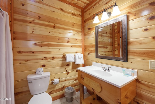 bathroom with vanity, toilet, and wood walls