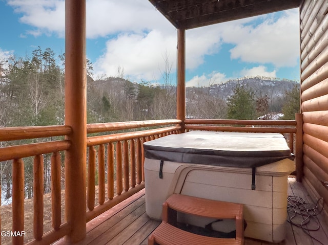 wooden terrace featuring a hot tub and a mountain view