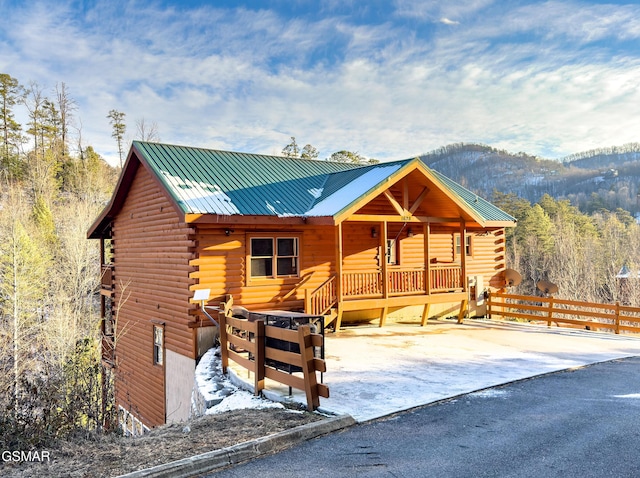 log cabin with a porch and a mountain view