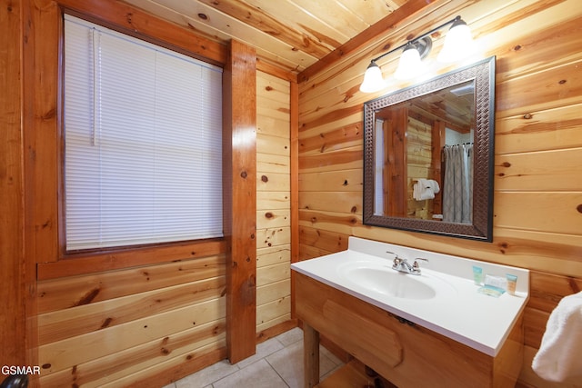 bathroom featuring walk in shower, wooden walls, tile patterned flooring, and sink