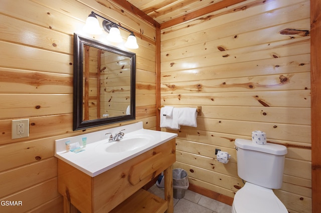 bathroom featuring vanity, wooden walls, and toilet