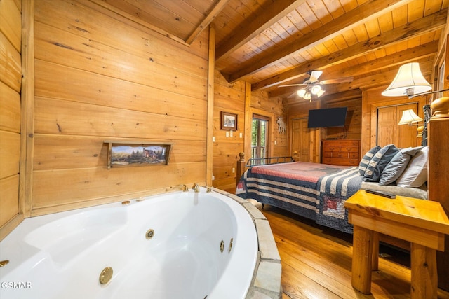 bedroom with wooden ceiling, light hardwood / wood-style floors, beam ceiling, and wooden walls