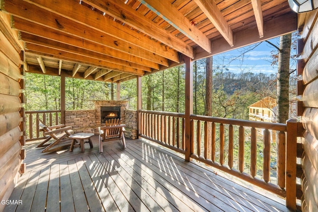 wooden terrace with an outdoor stone fireplace