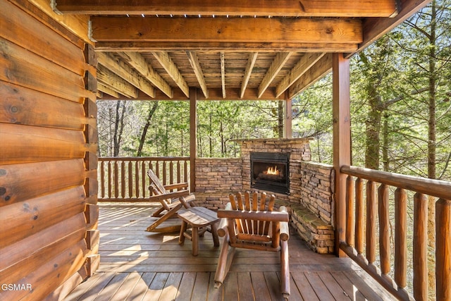 wooden terrace with an outdoor stone fireplace