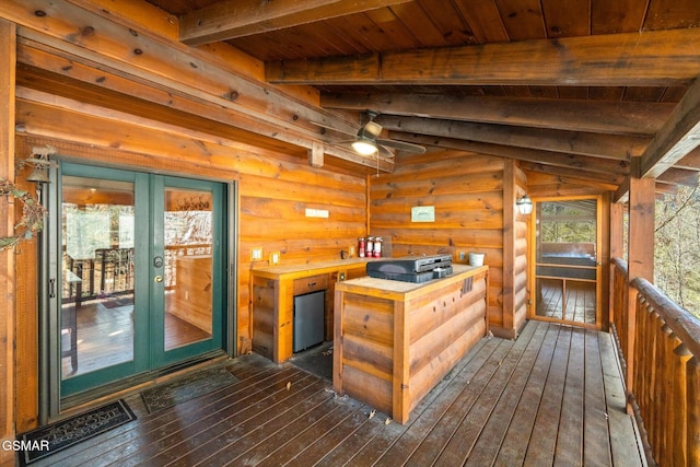 interior space featuring ceiling fan, dark hardwood / wood-style flooring, rustic walls, butcher block counters, and wooden ceiling