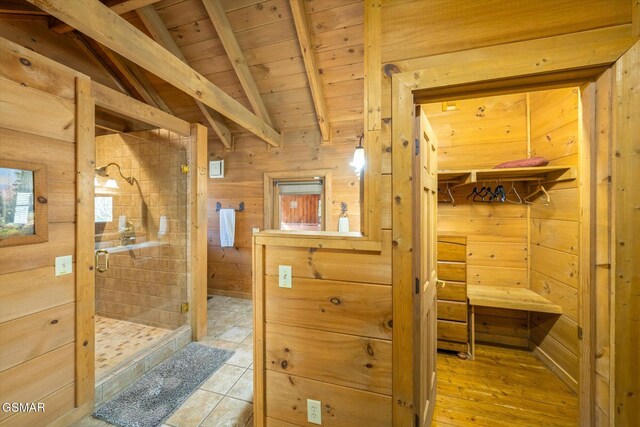 bathroom with wood ceiling, vaulted ceiling with beams, wooden walls, and an enclosed shower