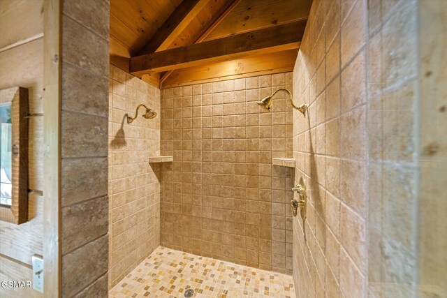 bathroom with vaulted ceiling with beams, tiled shower, and wooden ceiling