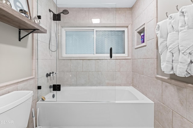 bathroom featuring toilet, tile walls, and tiled shower / bath