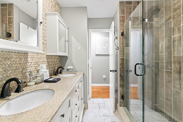 bathroom with decorative backsplash, vanity, tile patterned flooring, and a shower with shower door