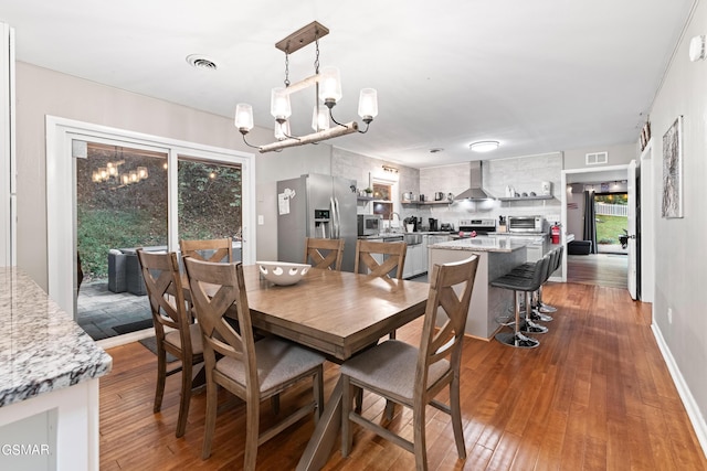 dining area with dark wood-type flooring and a chandelier