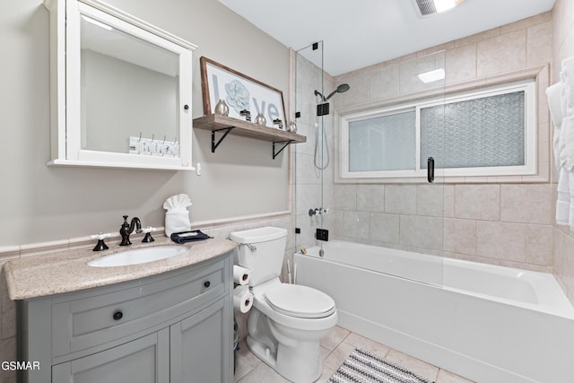 full bathroom featuring tile patterned floors, vanity, tile walls, toilet, and tiled shower / bath