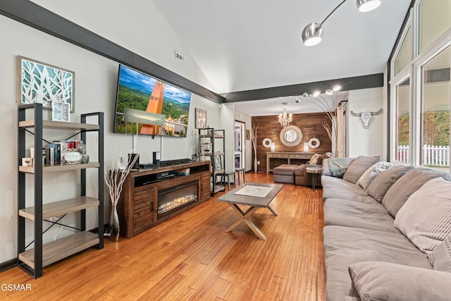 living room featuring wood-type flooring, lofted ceiling, and a notable chandelier