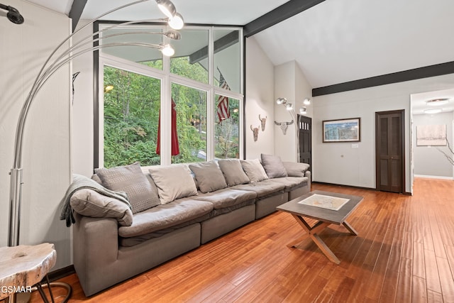 living room with vaulted ceiling with beams, hardwood / wood-style floors, and an inviting chandelier