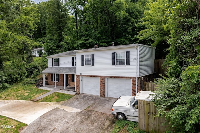 4220 Reed Rd, Louisville, TN 37777 - view of front of house with driveway, a porch, brick siding, an attached garage, and a chimney