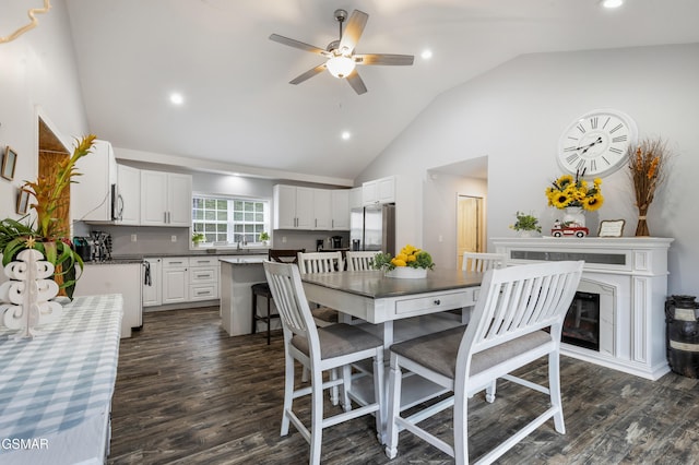 dining room featuring ceiling fan, dark wood finished floors, a glass covered fireplace, and recessed lighting