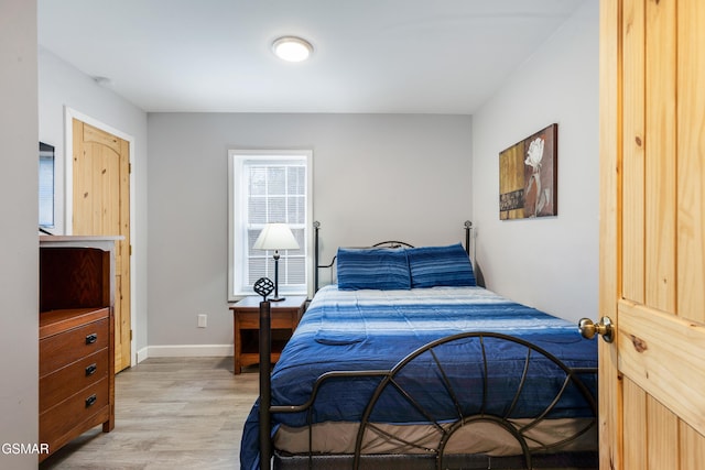 bedroom featuring light wood-style floors and baseboards