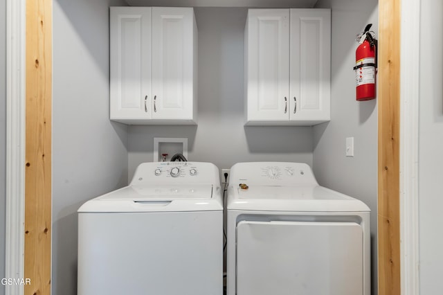 clothes washing area with cabinet space and independent washer and dryer