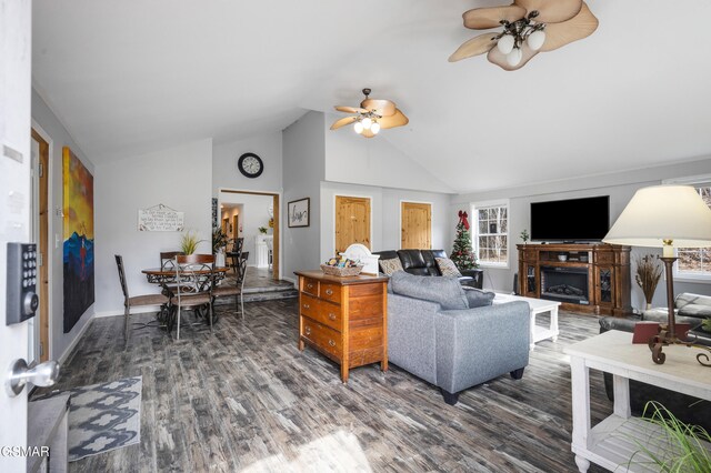 living area with ceiling fan, a fireplace, high vaulted ceiling, and wood finished floors