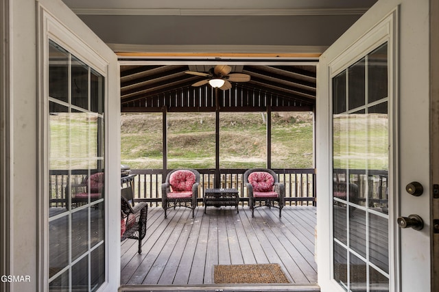 unfurnished sunroom with vaulted ceiling and ceiling fan