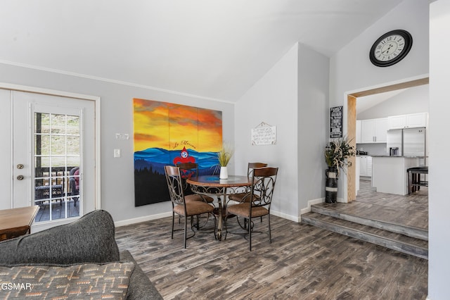 dining area featuring lofted ceiling, baseboards, and dark wood-style flooring