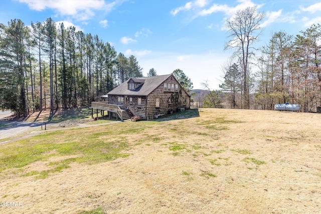 view of front of home featuring a wooden deck, a front yard, and stairway