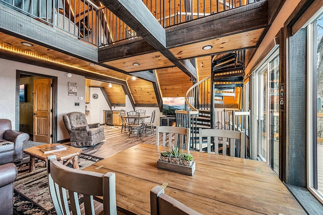 dining space with hardwood / wood-style floors and high vaulted ceiling