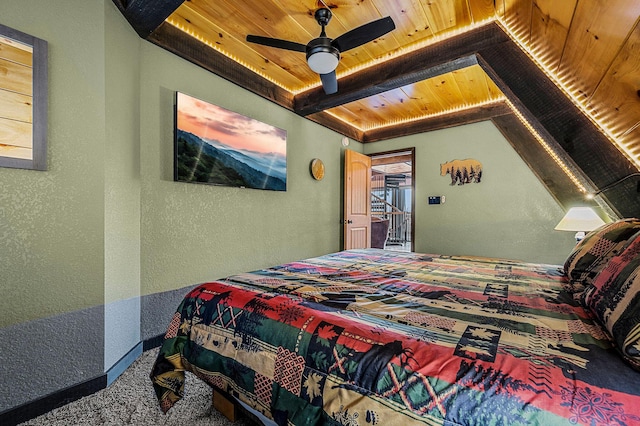 carpeted bedroom with ceiling fan, beam ceiling, and wooden ceiling